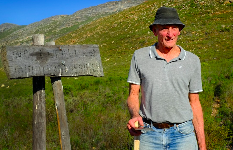 Peter beside the sign he made 23 years ago